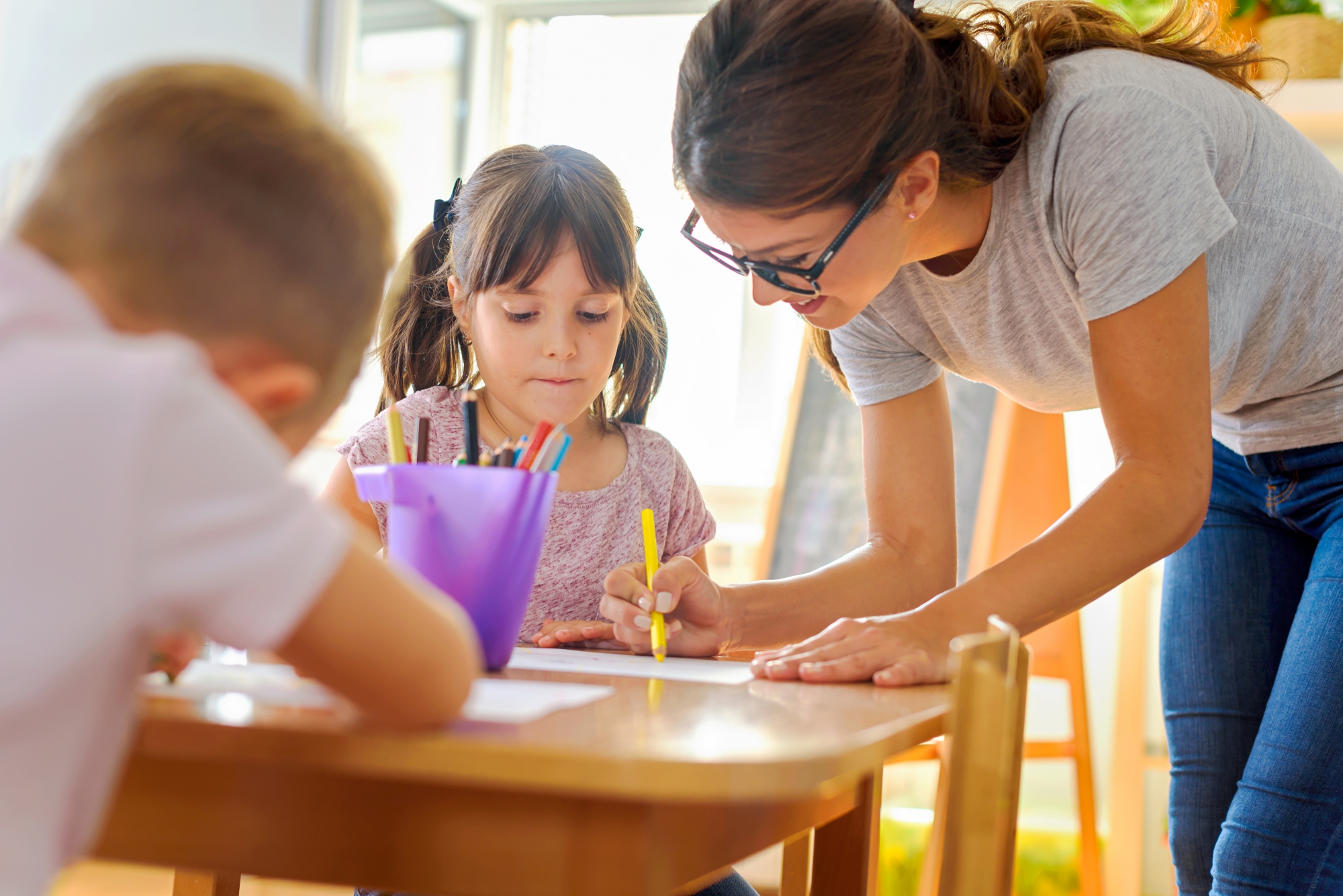 a teacher looking at something with a child