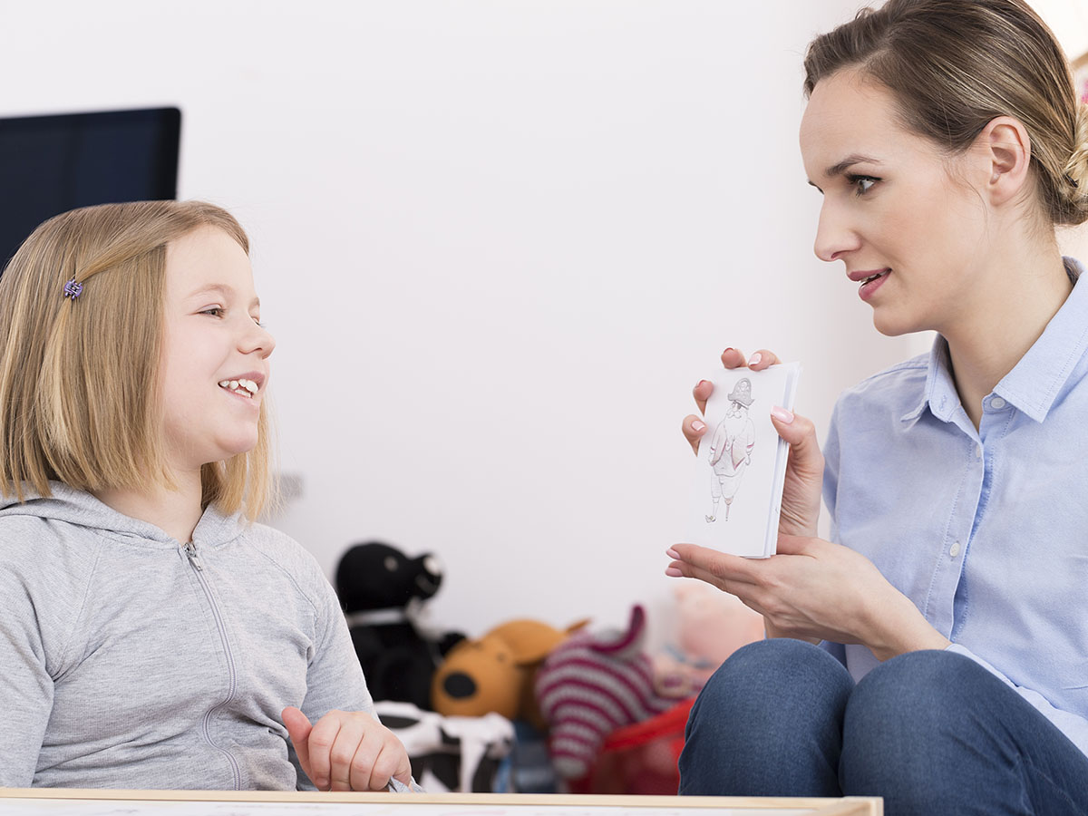 Person showing a kid a picture card