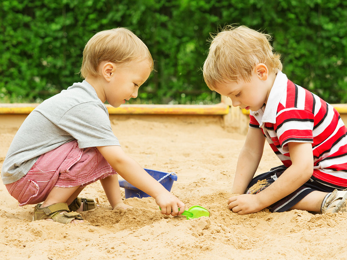 Two boys playing in a sandbox