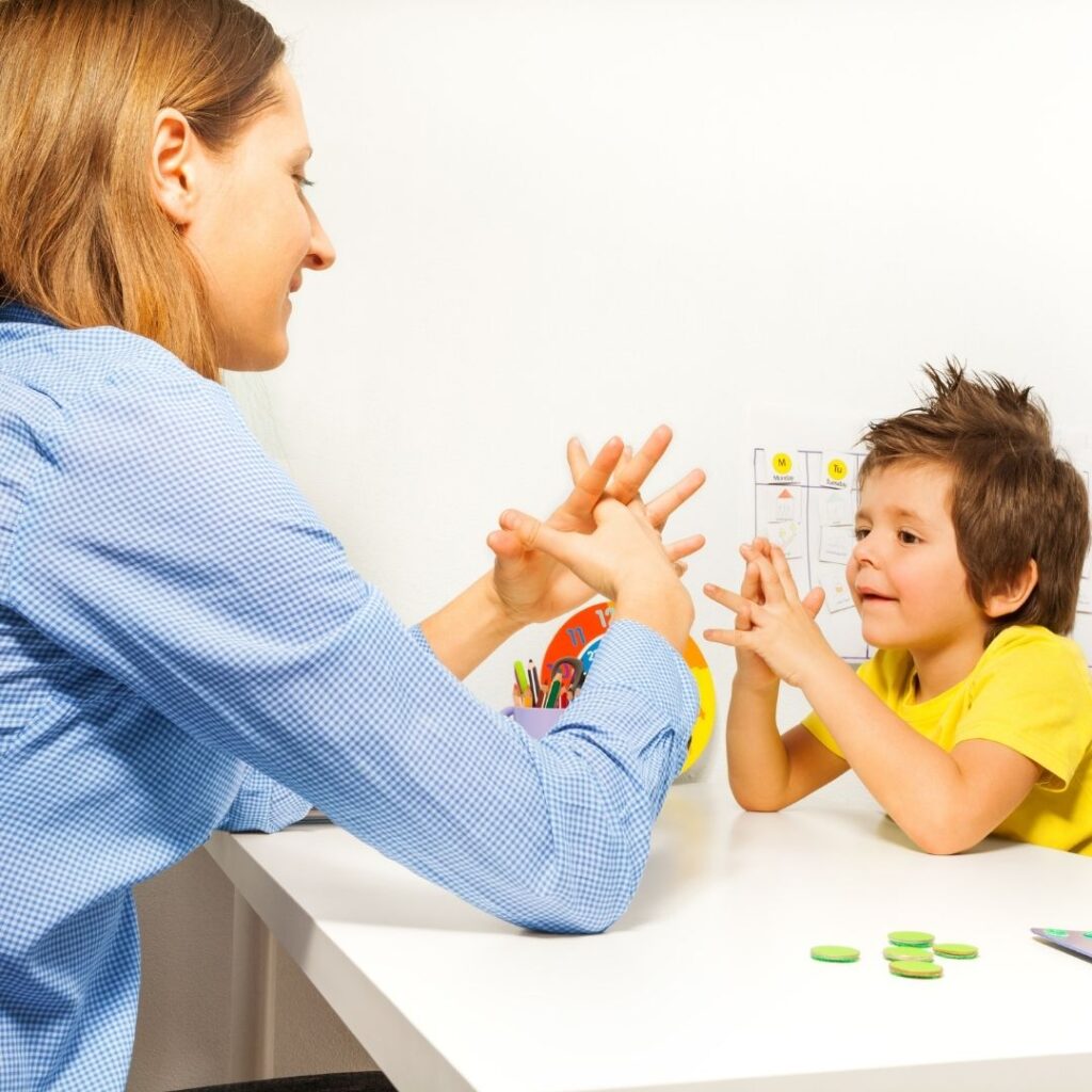 An autistic boy learning with a teacher.