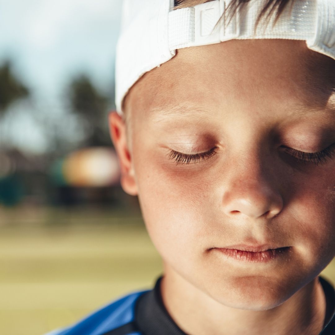 kid in backwards hat with eyes closed