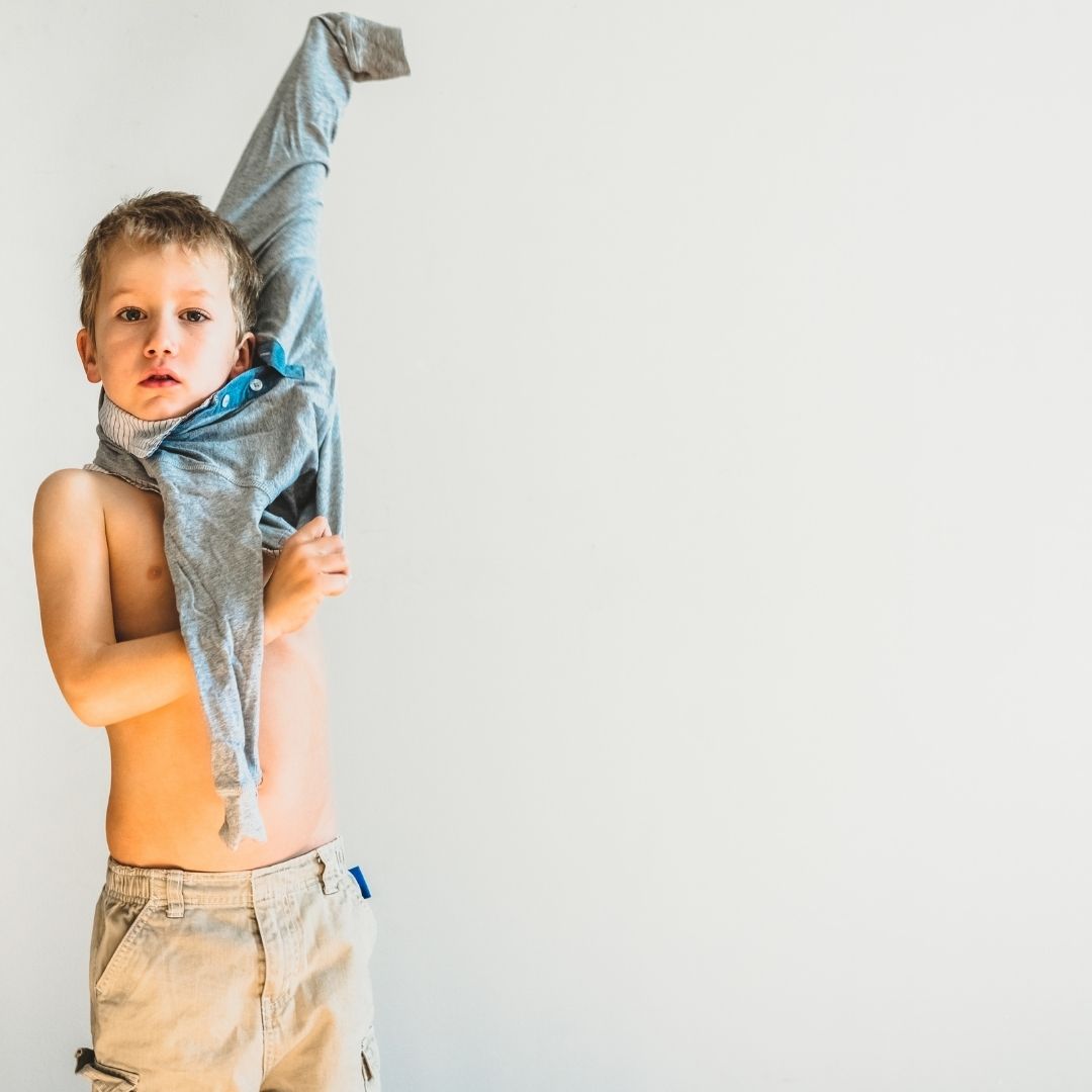 kid putting on long sleeve shirt
