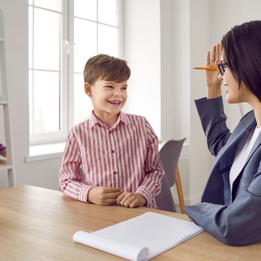 Child smiling while talking with adult