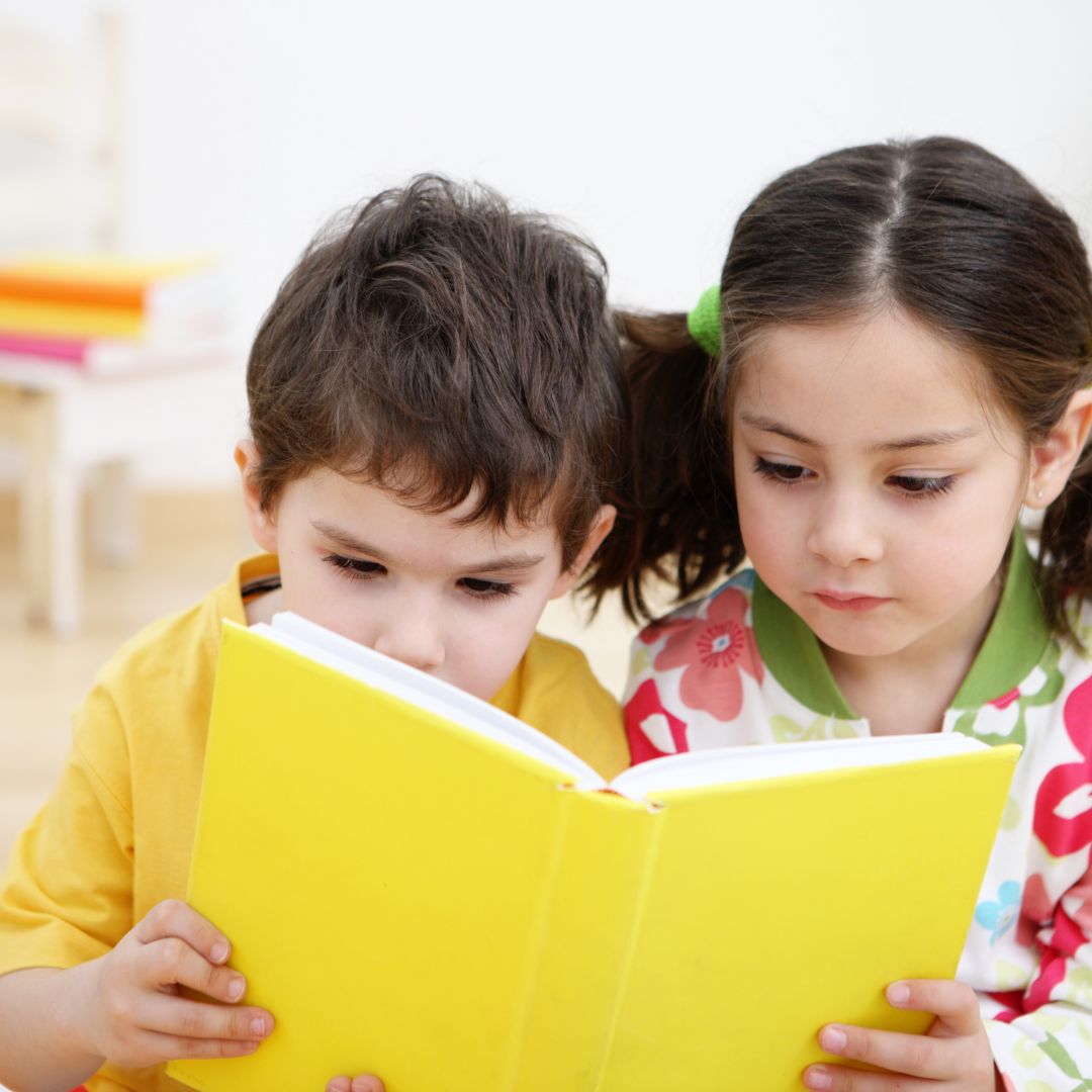 Two children reading the same book
