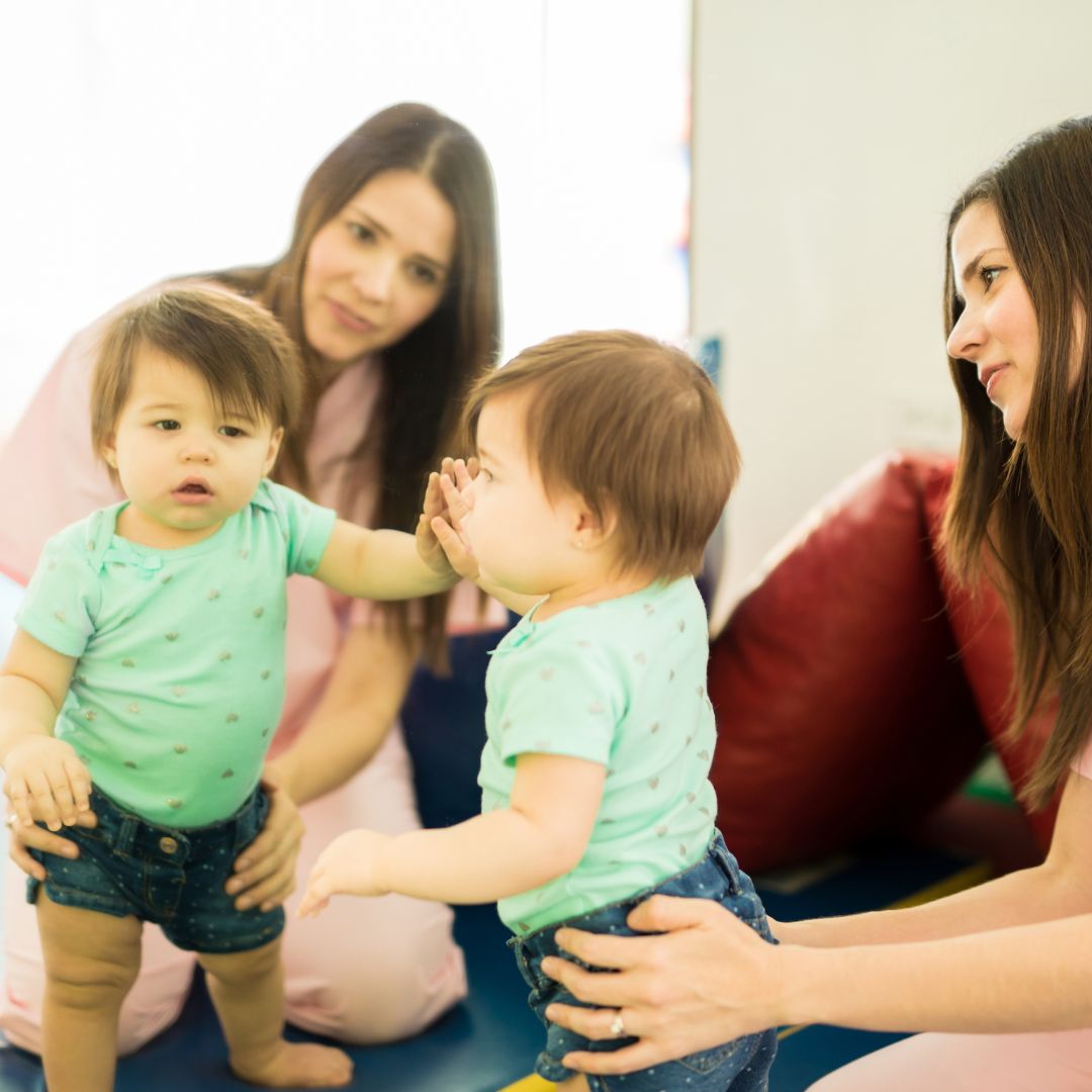 Toddler and mother looking at their reflections in mirror