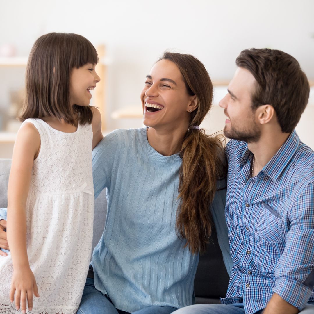 Parents laughing with daughter