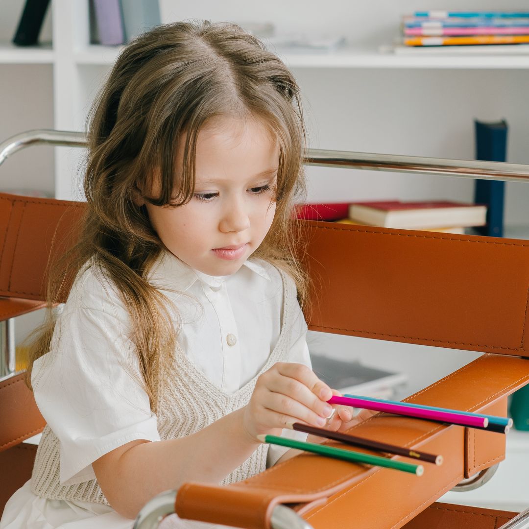 little girl looking at pencils