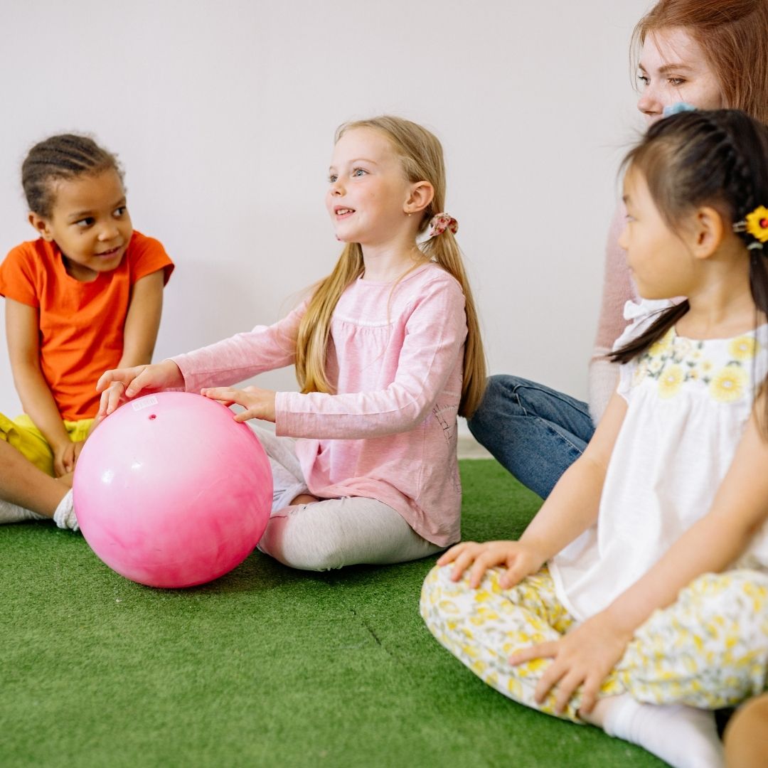 therapist with 3 children playing with a ball