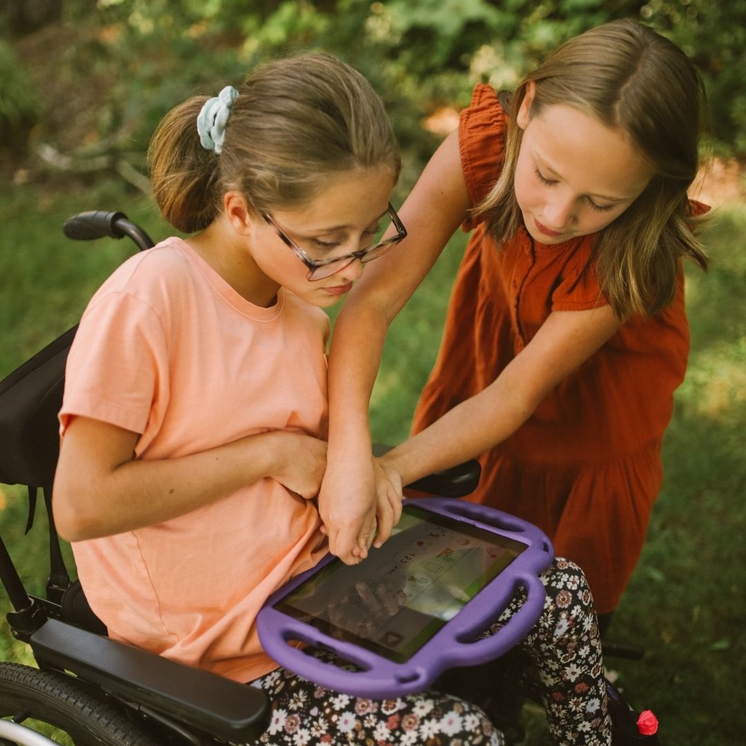 sister helping to use communication tablet