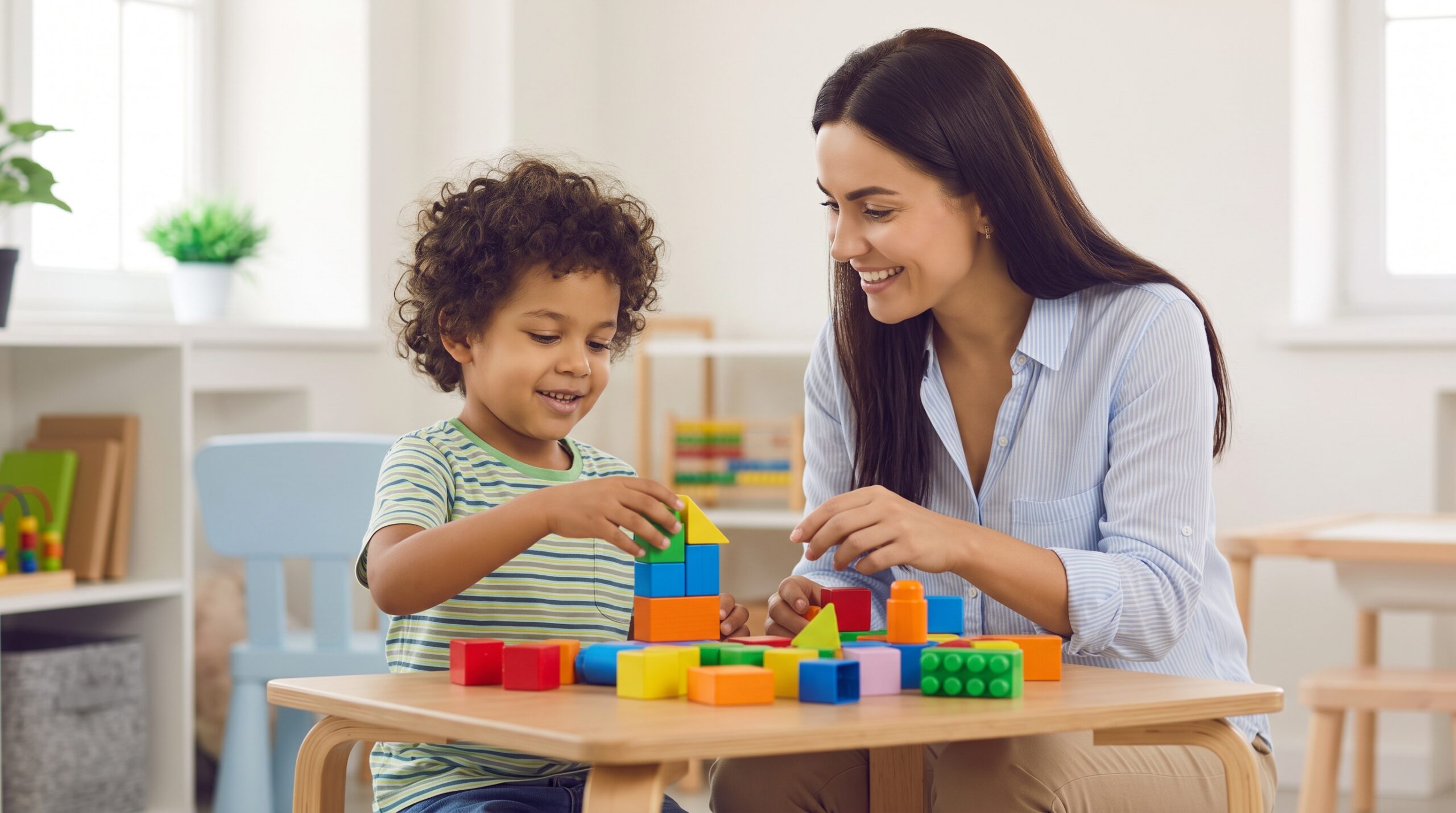 A specialist and a young child smiling while interacting in a supportive, play-based observation session.