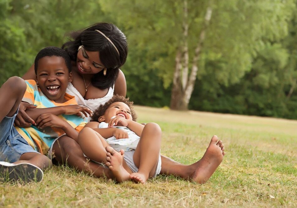 a mother and her two children playing in the park