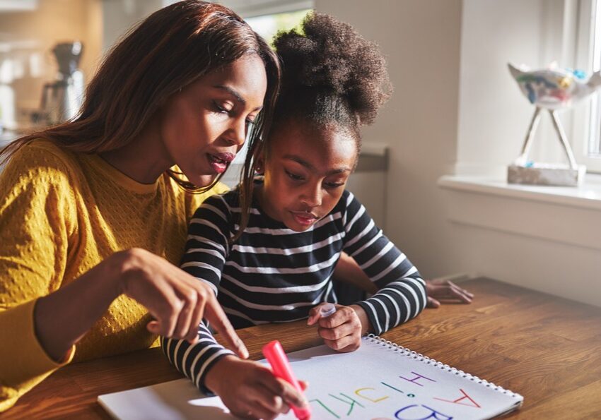 a teacher and girl learning to write